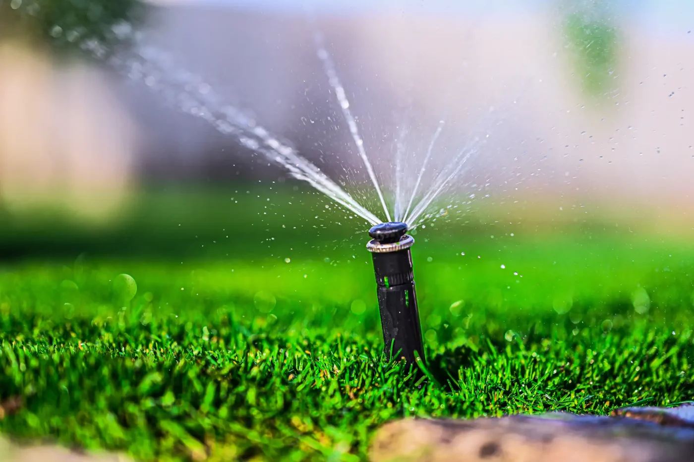 A modern sprinkler waters lush, green grass, highlighting a quality sprinkler system in Palm Beach County, FL.