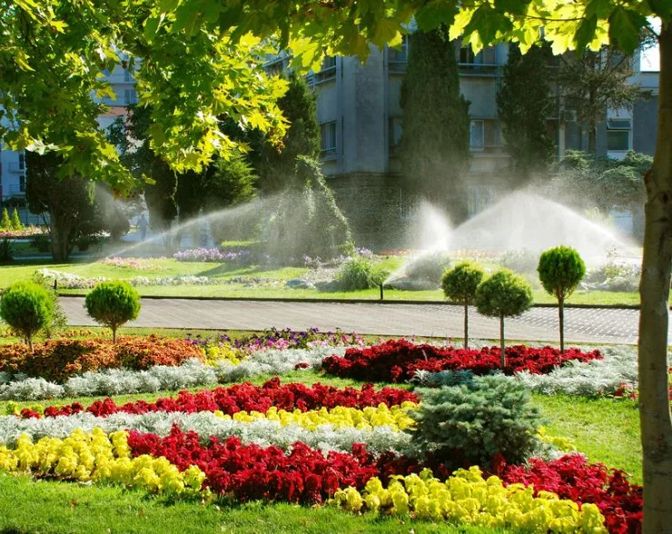 A landscaped garden showcases colorful flower beds and sprinklers installed by Palm Beach County, FL experts.